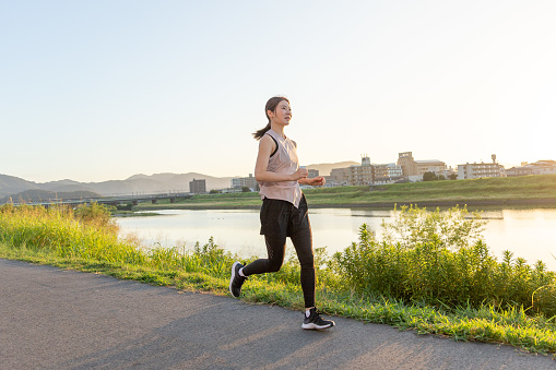 Beautiful Japanese girl running comfortably at sunrise