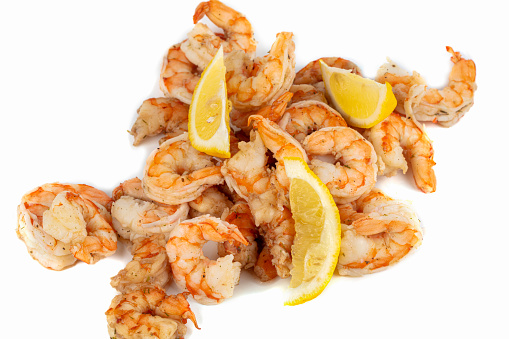 Shrimps cooked with lemon slices close-up on a white background.
