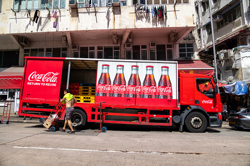 Hong Kong - September 26, 2023 : Deliveryman and Coca-Cola delivery truck in Kowloon, Hong Kong.