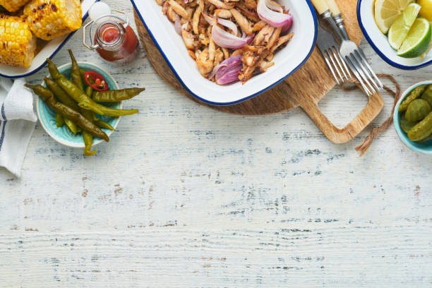 istock Pulled bbq chicken with baked onions on serving platter, bbq corn, pickles, chili peppers and buns for hot dogs and burgers, tomato sauce. Traditional American grilled summer bbq sandwiches dishes. 1702430765
