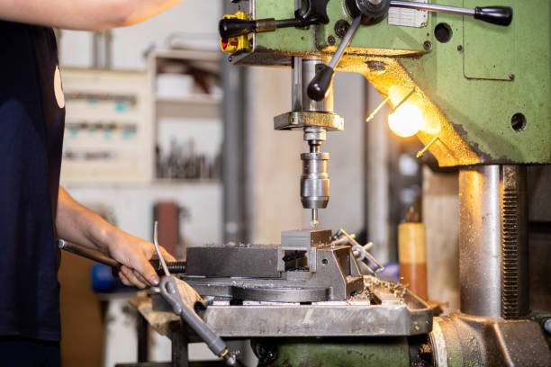 istock Man drilling with industrial machine in a metal factory workshop. 1702435382