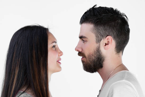 istock Young couple resist embracing against white background 1702445354