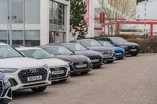 Trentham, Stoke-on-Trent, England, February 10th 2023. A row of Audis parked at a dealership lot, transport and retail editorial illustration.