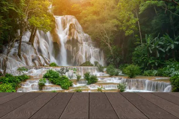 Wooden perspective shelf display desk layout for product promote, mockup table copy space for design, nature beautiful smoot Kuangsi Luangprabang waterfall, luxury material wallpaper floor