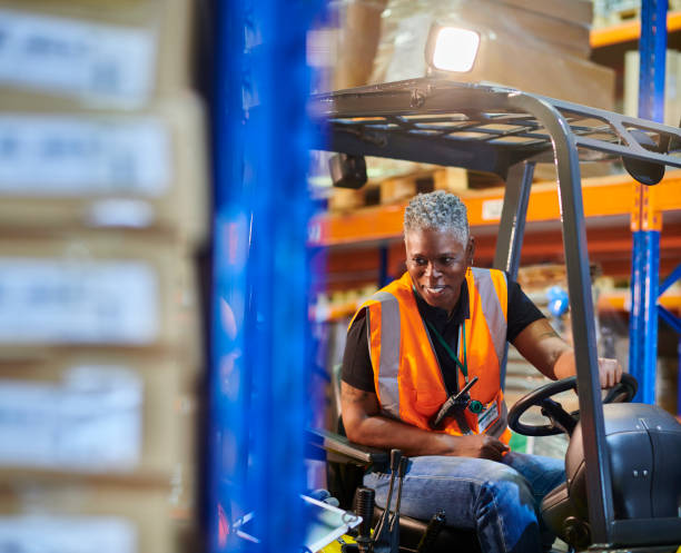 istock female fork lift driver with colleague 1702490034