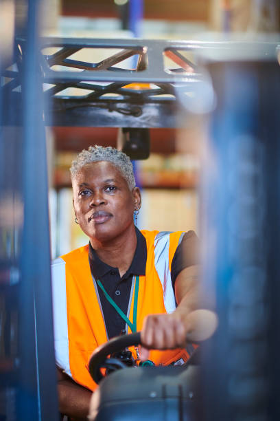 istock female fork lift driver in a warehouse 1702491672