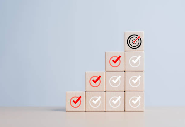 istock Checklist, Complete Task list. Goals achievement or enterprise objective target for company success. To do list. Check mark and dartboard from top of wooden cube stacks. Keys for success in business. 1702492228