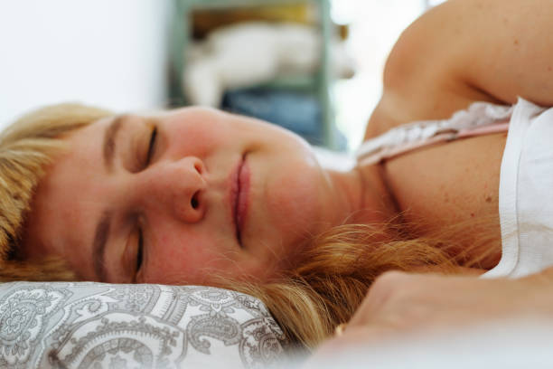 istock Attractive blonde woman waking up in bed 1702493604