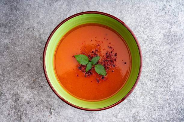 leckere tomatensuppe in keramikschüssel - tomato soup red basil table stock-fotos und bilder