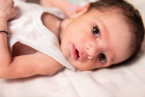 istock Beautiful little baby lying on bed with open eyes. 1702495102