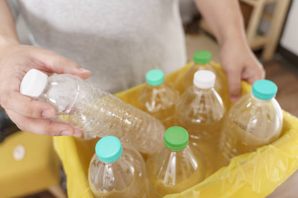 istock Home recycle eco green zero concept Man throwing empty plastic bottle in recycling bin with yellow garbage bags at home 1702507613