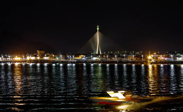 vista nocturna del pueblo acuático y el puente iluminado sungai kebun, bandar seri begawan, brunei - bandar seri begawan fotografías e imágenes de stock