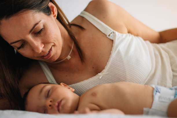 istock Mom looking at her baby in diaper while he is sleeping 1702540393