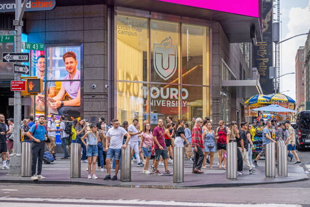 Times Square, Manhattan, New York, USA - August 12th 2023:  Large group of people waiting to cross the street in a zebra crossing