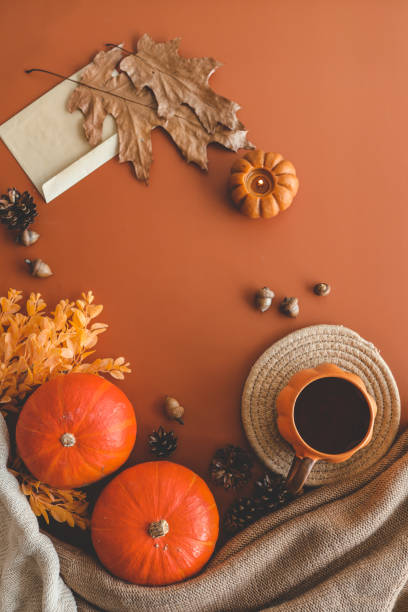 istock Autumn background top view, pumpkin and leaves on orange background 1702543702
