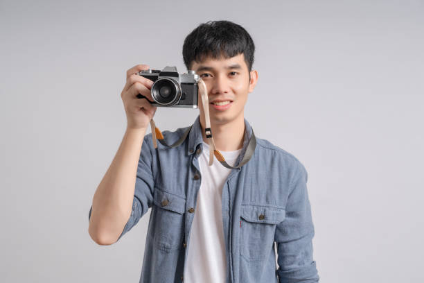 istock Person man holding camera and smiling happily. 1702545439