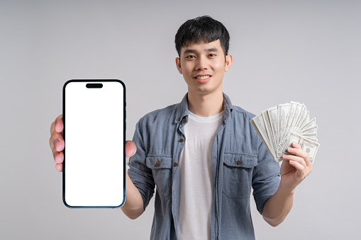 Man showing smartphone with blank white screen and holding dollar cash.