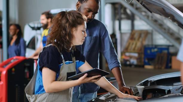 istock Worker informs man of car repair costs 1702562926