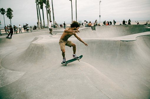 Venice Beach, CA, USA - Sep 17, 2023: The skater rides a skateboard through the bowl at the skatepark on Venice Beach.
