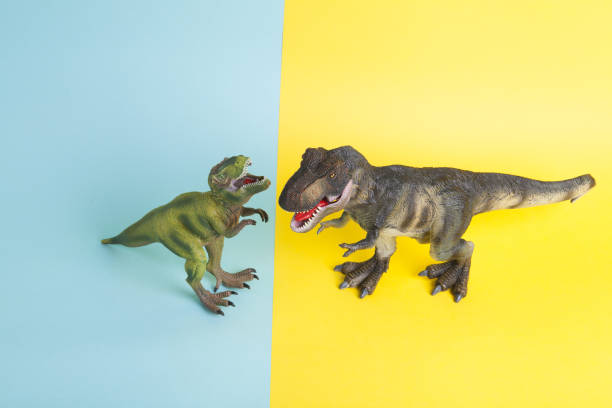 istock 2 dinosaurs fighting on a yellow and blue background 1702578483