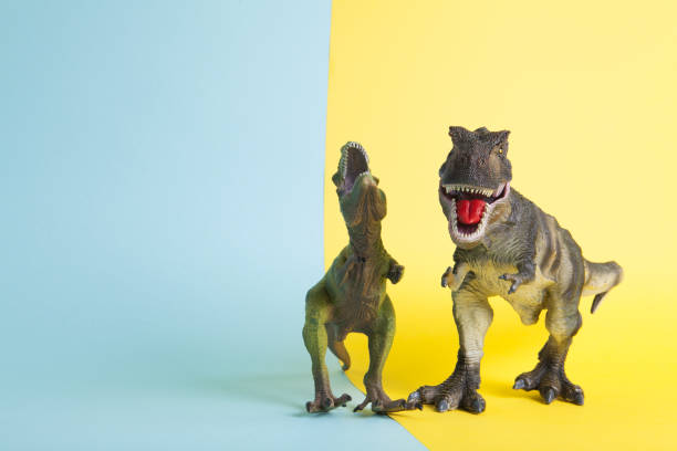 istock 2 dinosaurs fighting on a yellow and blue background 1702579057