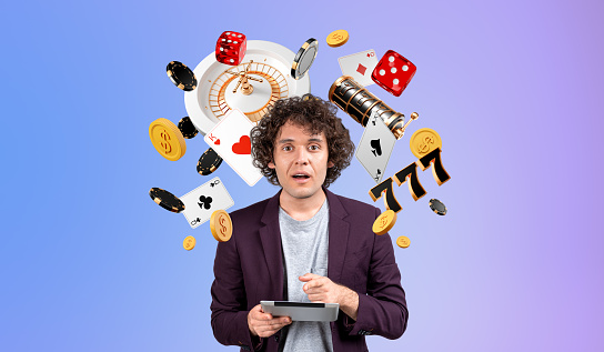 Astonished man finger point at tablet, looking at the camera with mouth opened. Casino jackpot and slot machine icons on gradient background. Concept of big win, luck and gambling