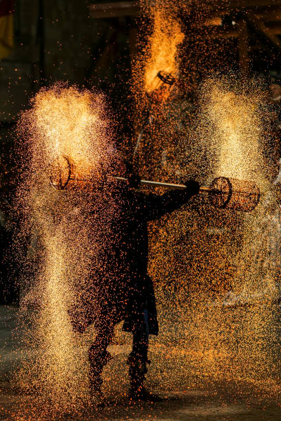 A spectacular fire dance with sparks during a medieval festival in a small town in Umbria in Italy A spectacular and awesome fire dance with thousands of sparks during a medieval festival and historical reenactment in the small town of Gualdo Tadino in Umbria, central Italy. The Umbria region, considered the green lung of Italy for its wooded mountains, is characterized by a perfect integration between nature and the presence of man, in a context of environmental sustainability and healthy life. In addition to its immense artistic and historical and medieval heritage, Umbria is famous for its food and wine production and for the high quality of the olive oil produced in these lands. Image in high definition quality. gualdo tadino stock pictures, royalty-free photos & images