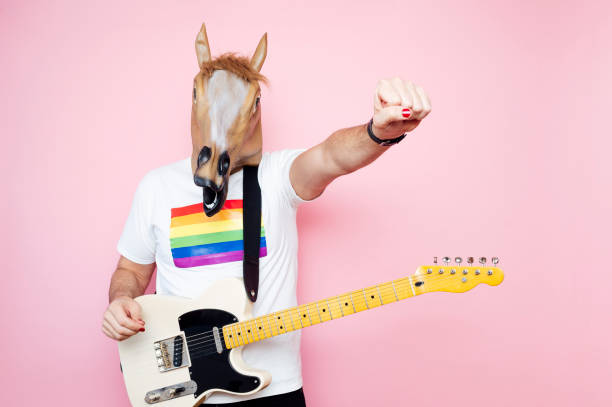 istock Man in a horse mask playing electric guitar. 1702607977