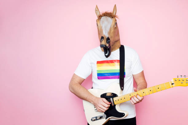 istock Man in a horse mask playing electric guitar. 1702607980