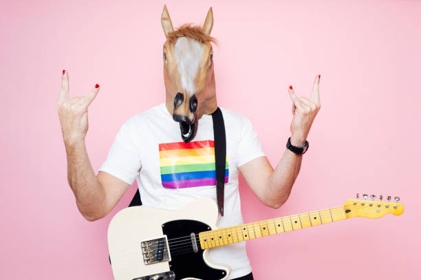 istock Man in a horse mask playing electric guitar. 1702607981