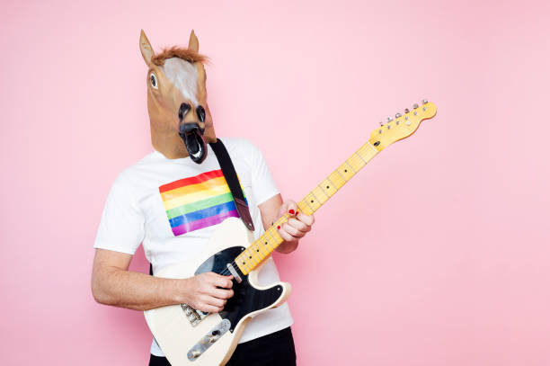 istock Man in a horse mask playing electric guitar. 1702607987