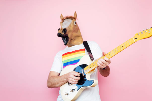 istock Man in a horse mask playing electric guitar. 1702607989