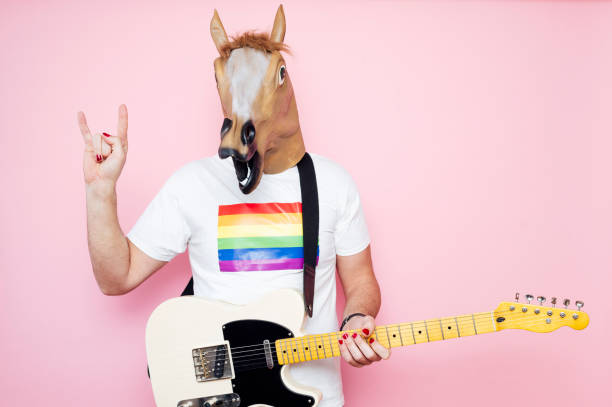 istock Man in a horse mask playing electric guitar. 1702608526