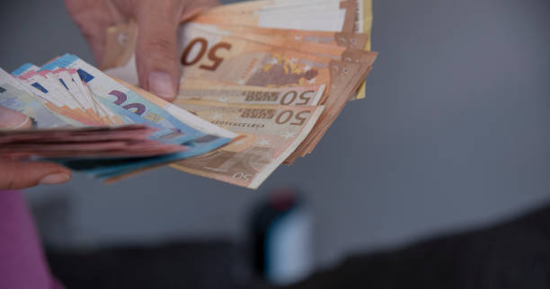 istock Close-up Of Person Hand Showing Euro bancnotes. 1702608538