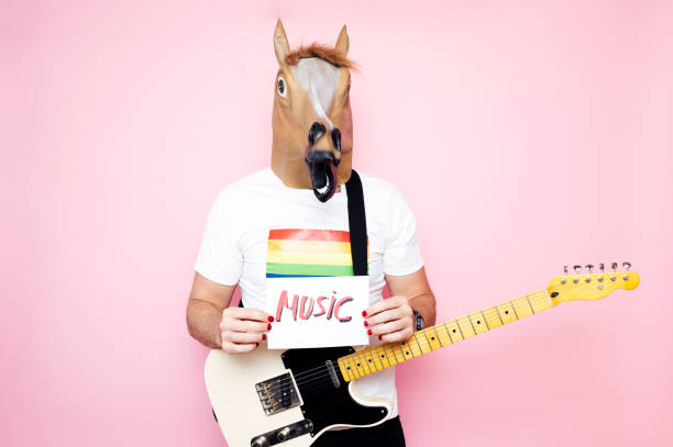 istock Man with horse mask holds a poster that puts music 1702609089