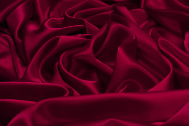 istock Rich and luxury red silk fabric texture background. 1702612419