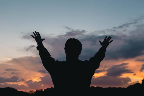 istock A man raises his hands to the sky, thanks God. 1702625162