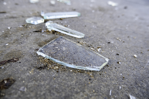 Detail of broken glass thrown in the trash, crime