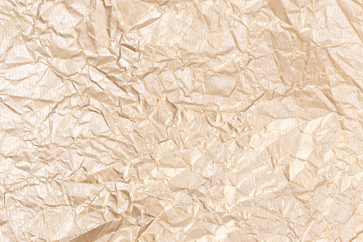 Golden crumpled paper texture background. Full frame