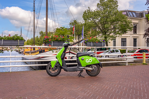 Leeuwarden, Netherlands - June 12, 2021: Green parked GO Sharing scooter in Leeuwarden