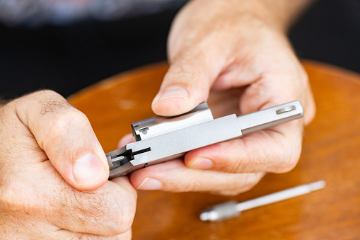 This is a photograph of an unrecognizeable man putting a small .22 caliber revolver pistol gun together at home in Florida, USA.