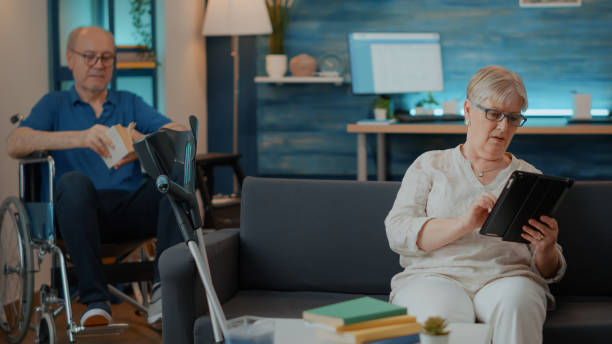 istock Retired woman browsing internet on digital tablet at home 1702700347