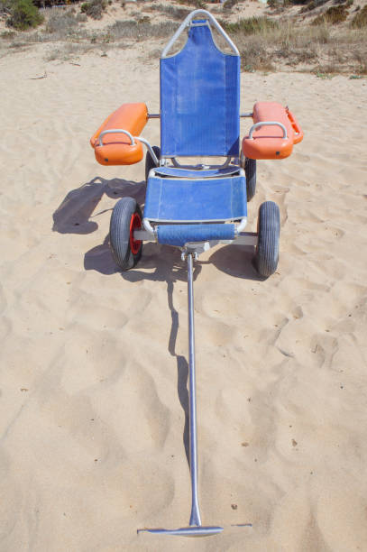 istock Blue beach wheelchair on sand ready to use 1702715726