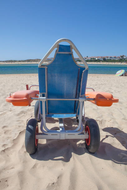 istock Blue beach wheelchair on sand ready to use 1702715734