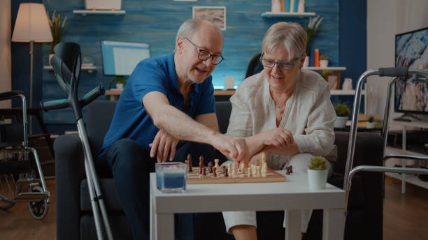 istock Senior couple playing chess board game with pieces 1702716303