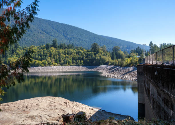 Scenic lake with dam and mountains during fall.