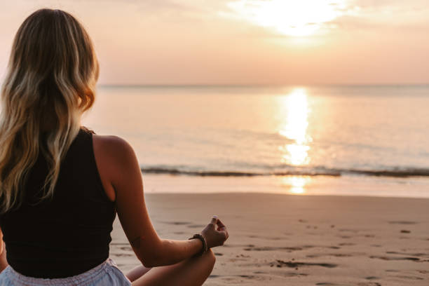 istock Young woman practicing yoga on the beach 1702734705