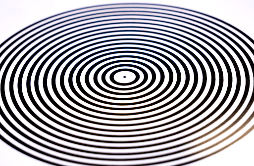 Abstract pop art circles, circular black and white monochrome hypnotic pattern closeup, soft focus, nobody. Background texture, no people, minimalism. Looping lines, central point striped circle shape