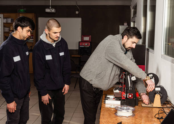 istock 3D scanning and printing training class. Teacher shows how to work on 3D scanner and printer 1702736536