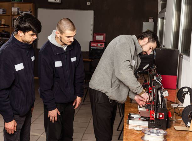 istock 3D scanning and printing training class. Teacher shows how to work on 3D scanner and printer 1702736564
